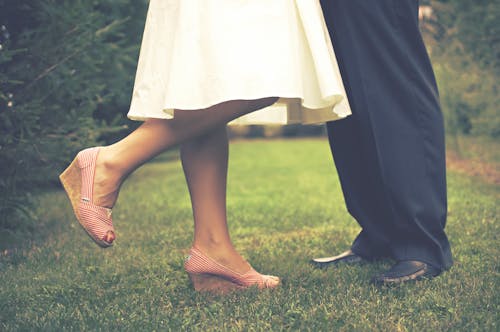 Free Man and Woman Standing on Grass Field Stock Photo