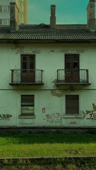 Aged building with graffiti on a sunny day, perfect for urban decay themes.