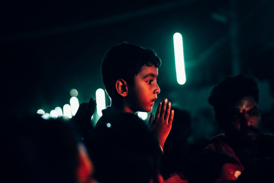 A young boy participates in a vibrant night festival in Thoothukudi, Tamil Nadu, India.
