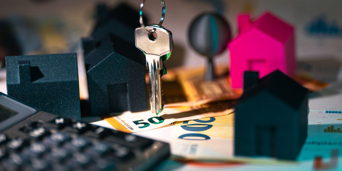 A symbolic representation of real estate finance featuring keys, model houses, and euro banknotes.
