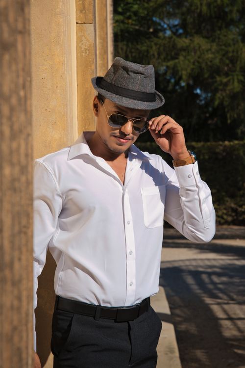 Free A fashionable man posing outdoors wearing a hat and sunglasses at Sanssouci Palace. Stock Photo