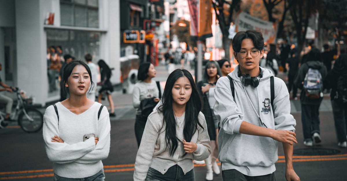 Meta and Rokid expand AI smart glasses into South Korea and Australia Group of young friends strolling through a lively street in Seoul, showcasing urban youth culture.