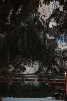 Serene scene of boats floating on a peaceful lake in the Italian Alps with lush greenery.