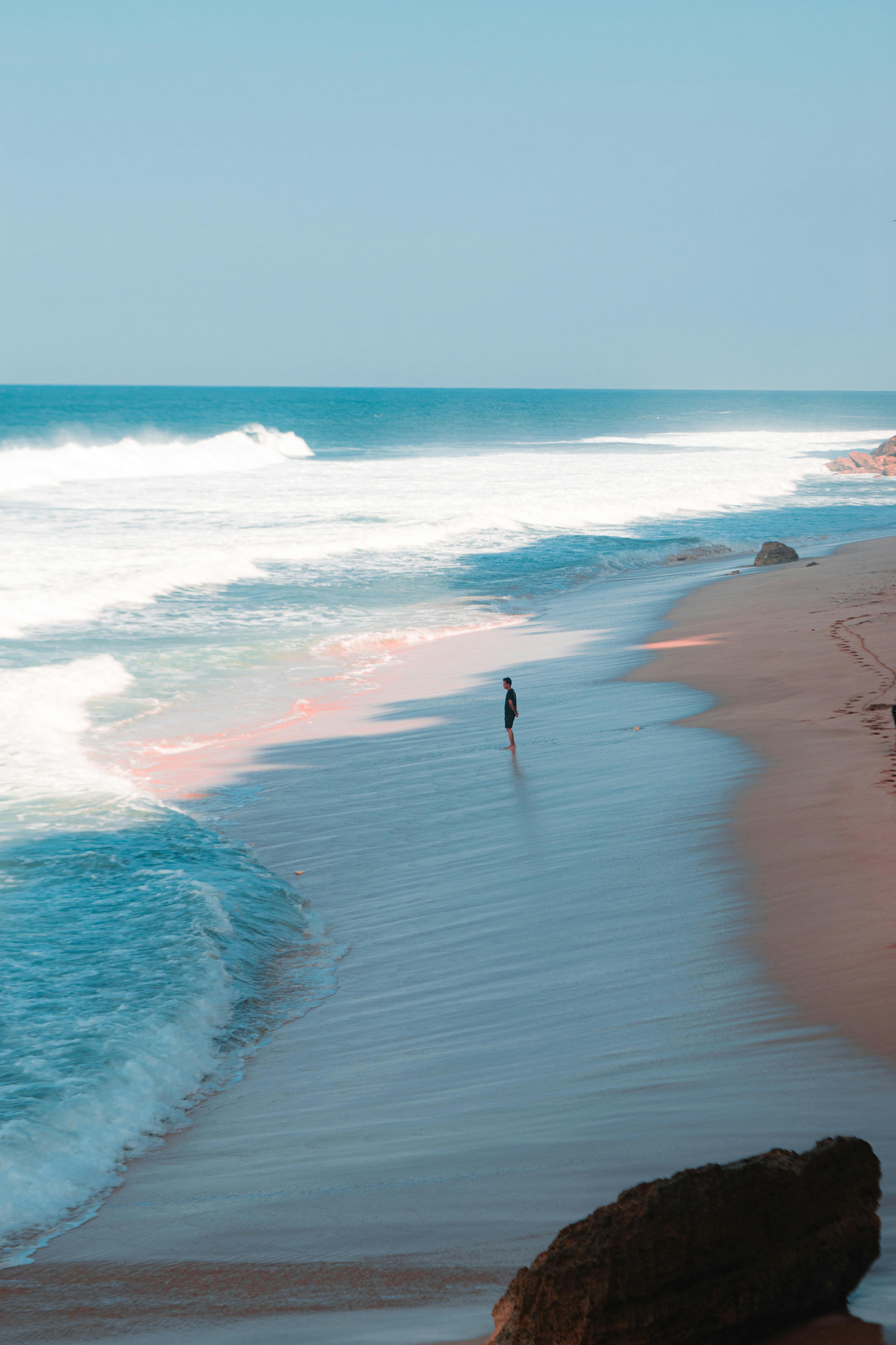 solitary figure strolling along yogyakarta beach