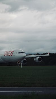 Airplane on runway ready for takeoff under cloudy skies, showcasing Swiss Airlines.