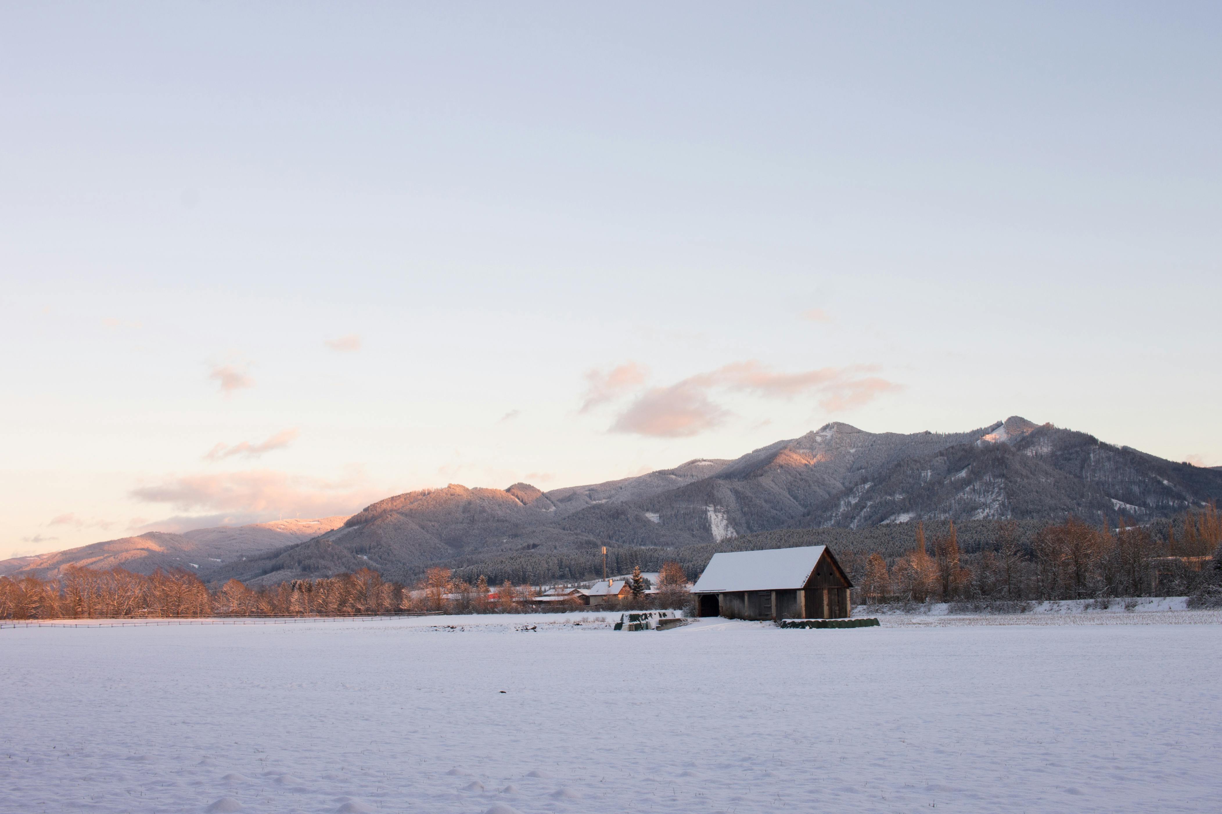 Scenic winter view of snow-covered mountains and fields in Krieglach, Austria.
