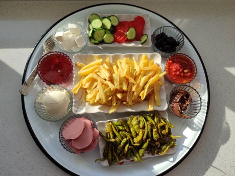 Vibrant food platter featuring vegetables, dips, and fries. Ideal for culinary presentations.