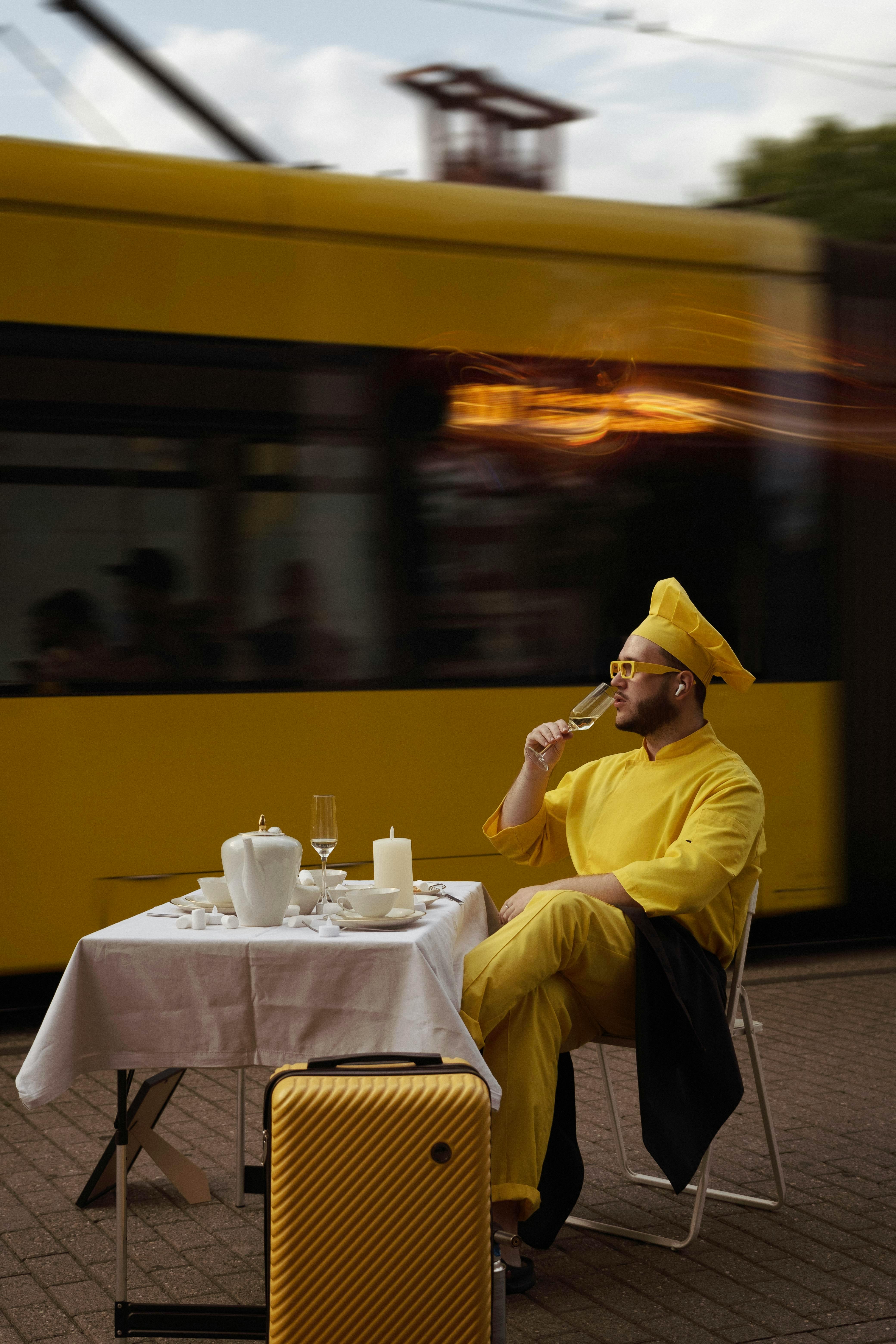 Kostnadsfria Man Klädd I Gult Njuter Av Dryck Mitt I Urban Scen Stock foto