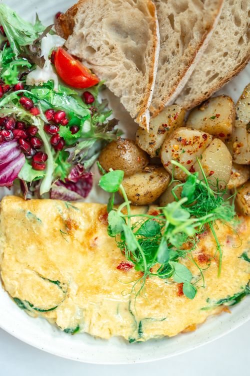 Free Top view of a delicious breakfast with omelette, salad, potatoes, and bread. Stock Photo