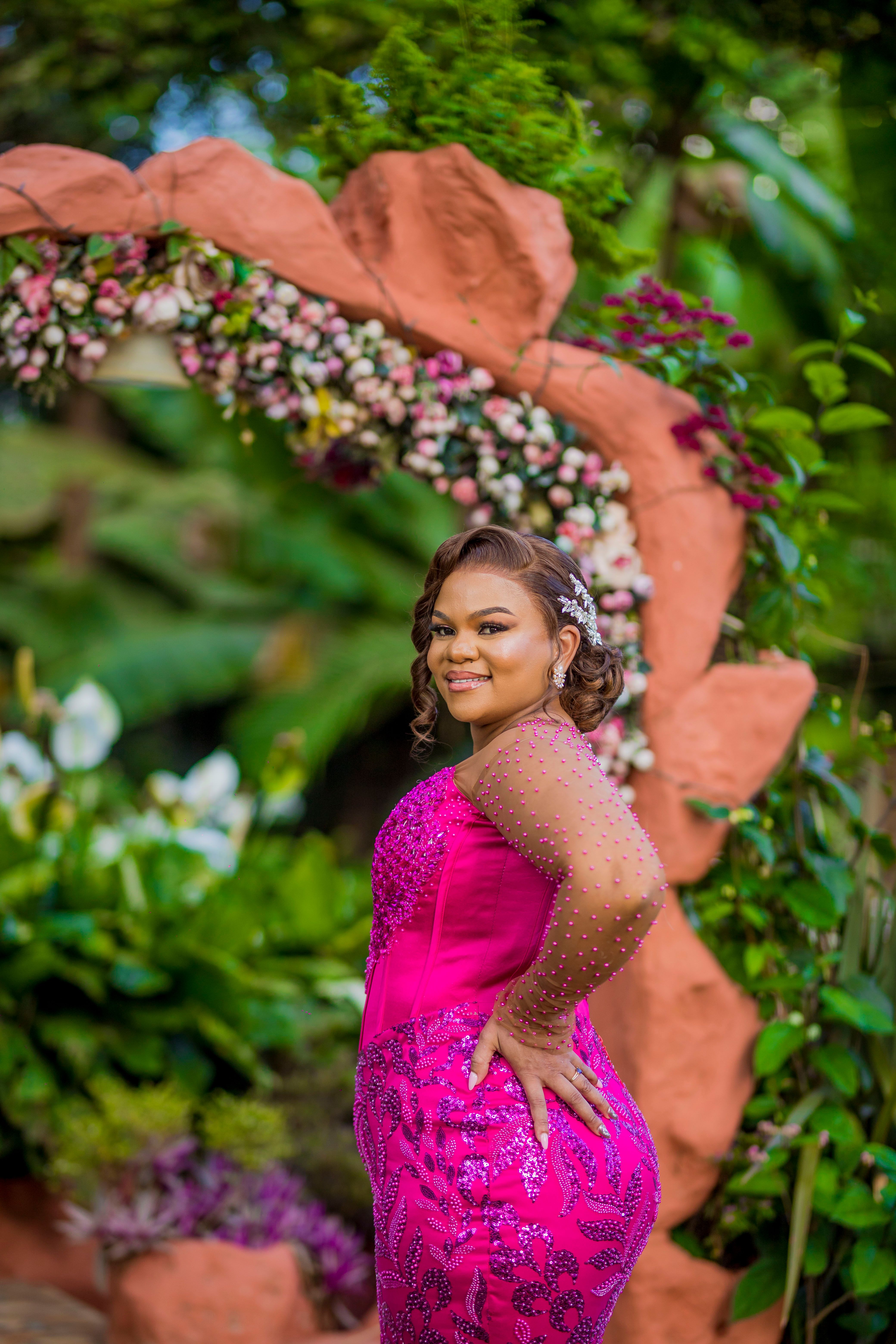 Elegant Woman in Pink Dress at Floral Arch Outdoors · Free Stock Photo