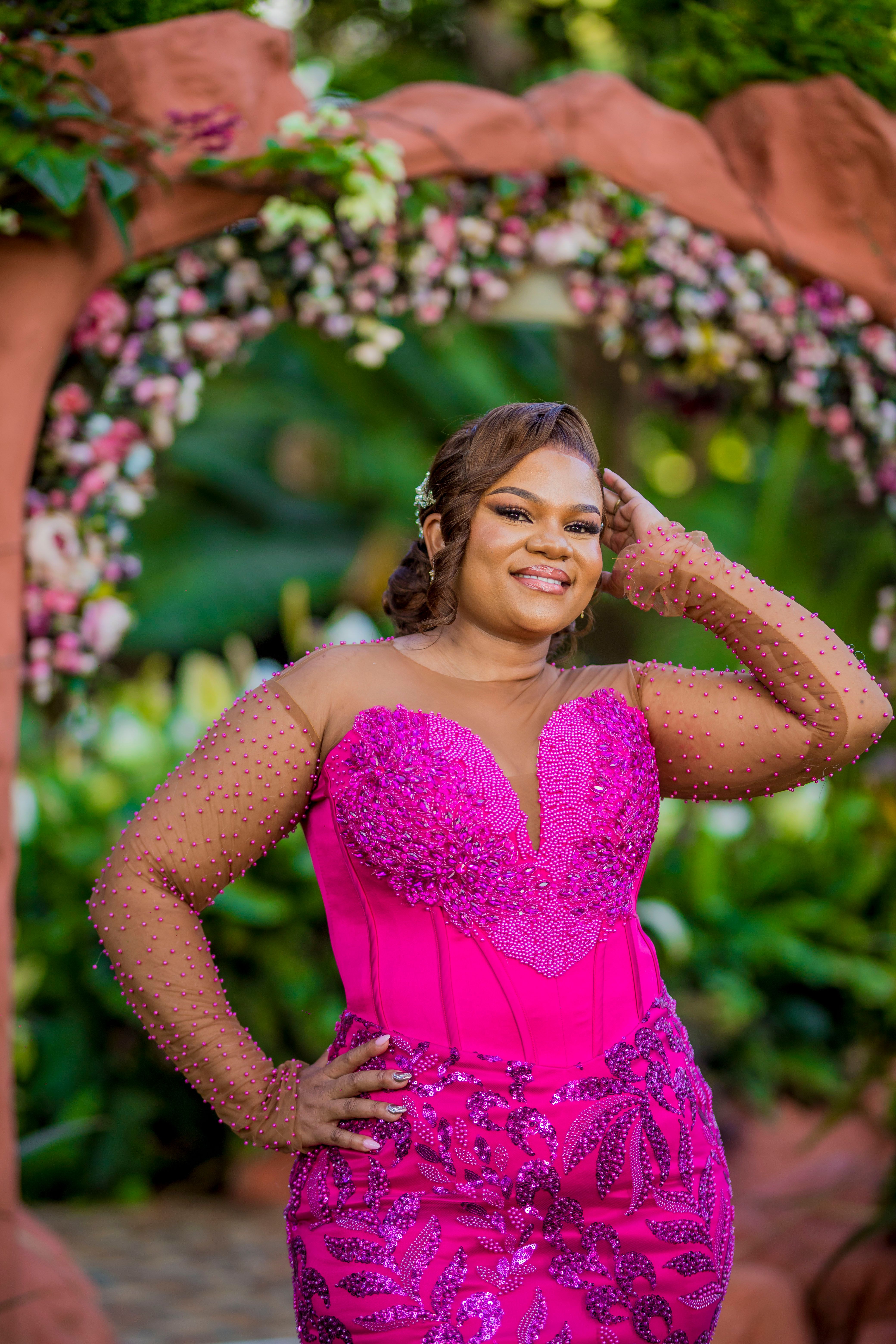 Elegant Woman in Pink Gown at Floral Archway · Free Stock Photo