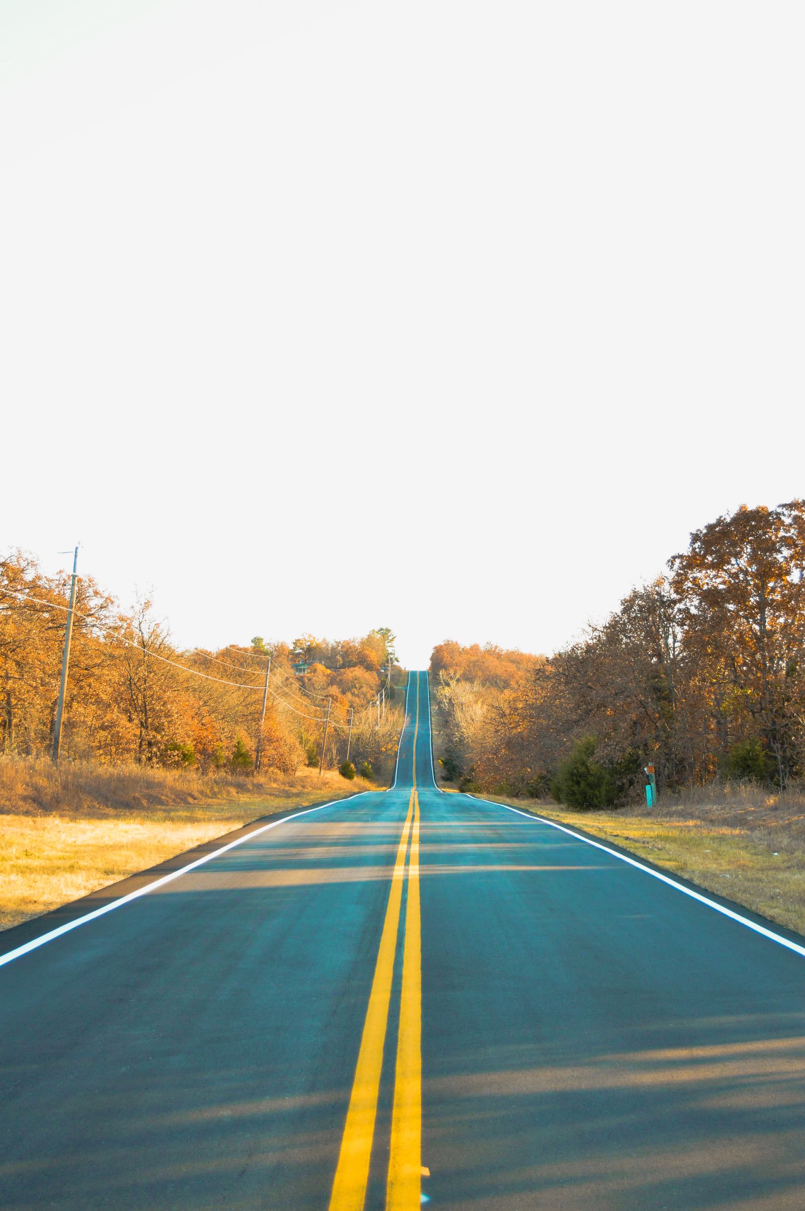 Two-lane autumn road through Oklahoma countryside near Sand Springs