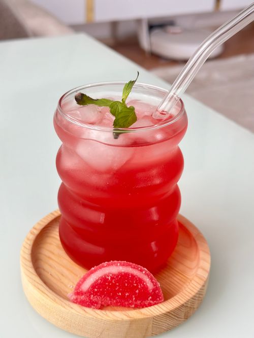 Free Refreshing red drink with ice and mint in a stylish glass on a wooden coaster. Stock Photo