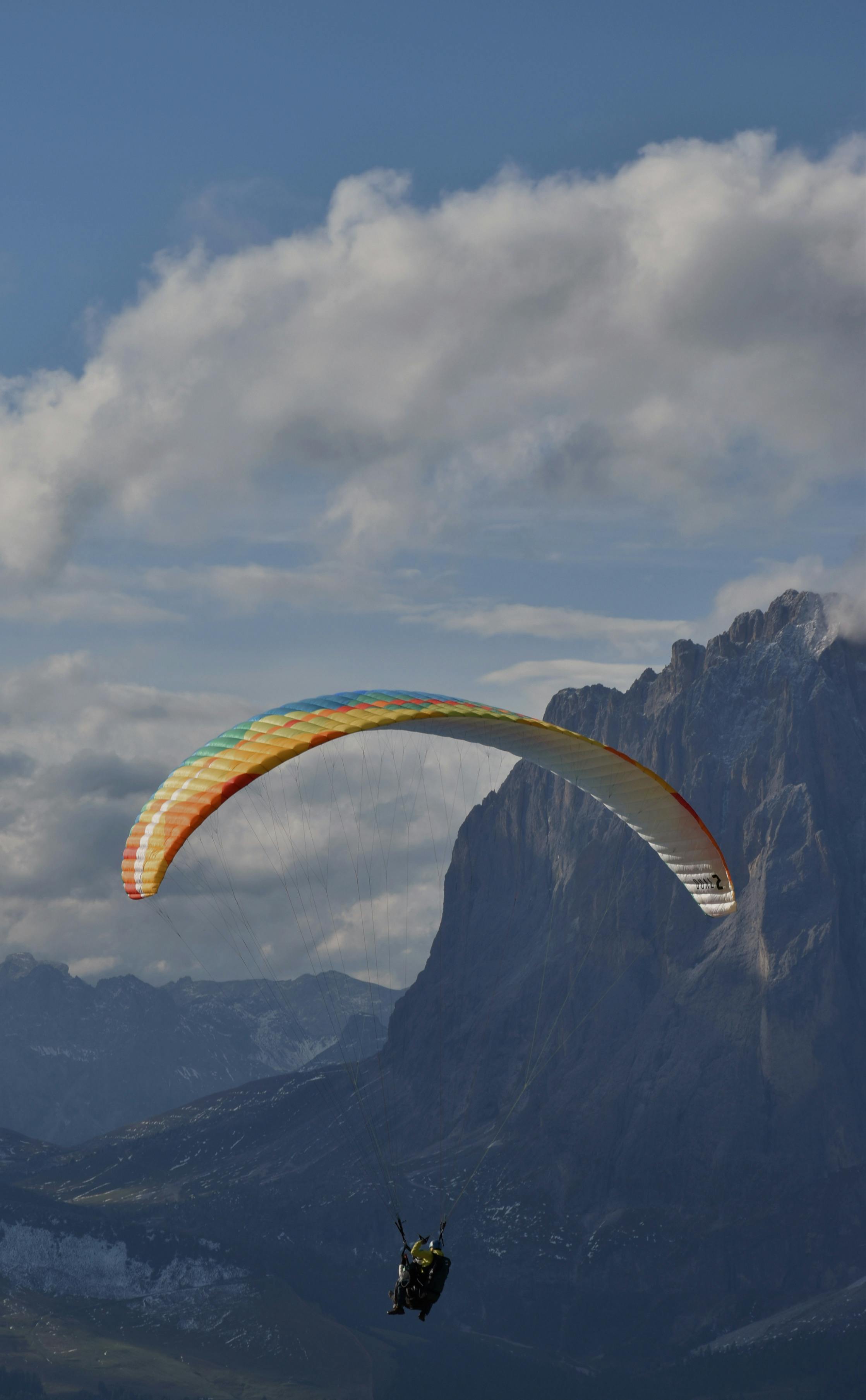 Paraglider soaring over the scenic Italian Alps in Veneto. Experience adventure.