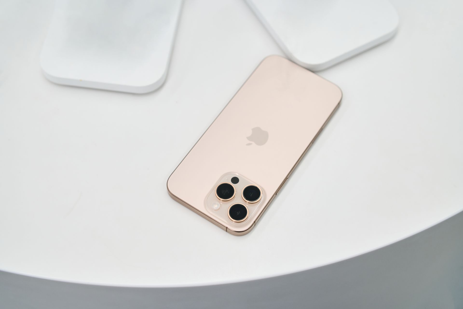 Golden smartphone with triple camera on a clean white surface. Modern design.