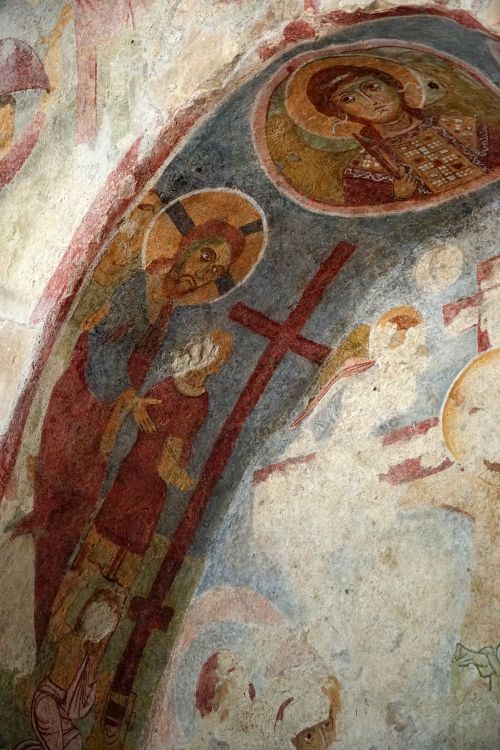 Free Intricate ancient religious fresco depicting sacred iconography on arched wall. Stock Photo