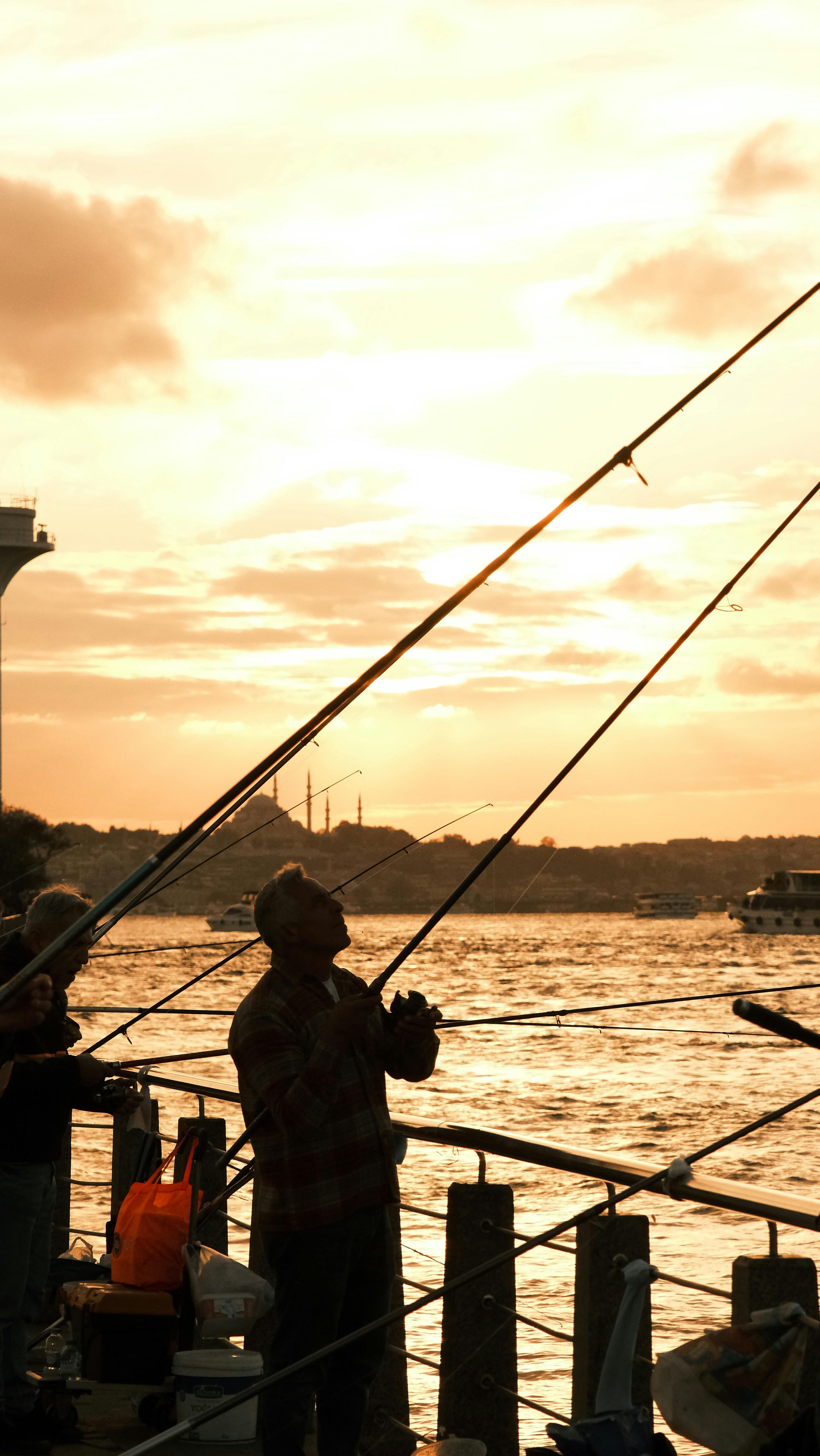 fishermen casting lines at sunset on scenic waterfront