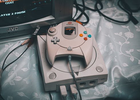 Close-up of a Sega Dreamcast console with controller and CRT monitor in a retro gaming setup.