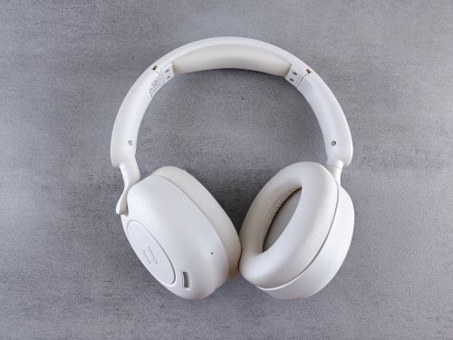 Free Close-up of sleek white wireless headphones on a textured gray surface. Ideal for audio enthusiasts. Stock Photo