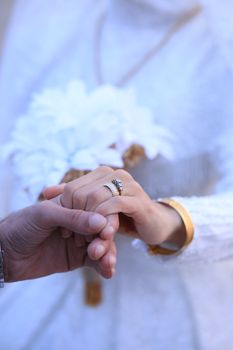 Close-up shot of a couple exchanging rings, a symbol of love and commitment.
