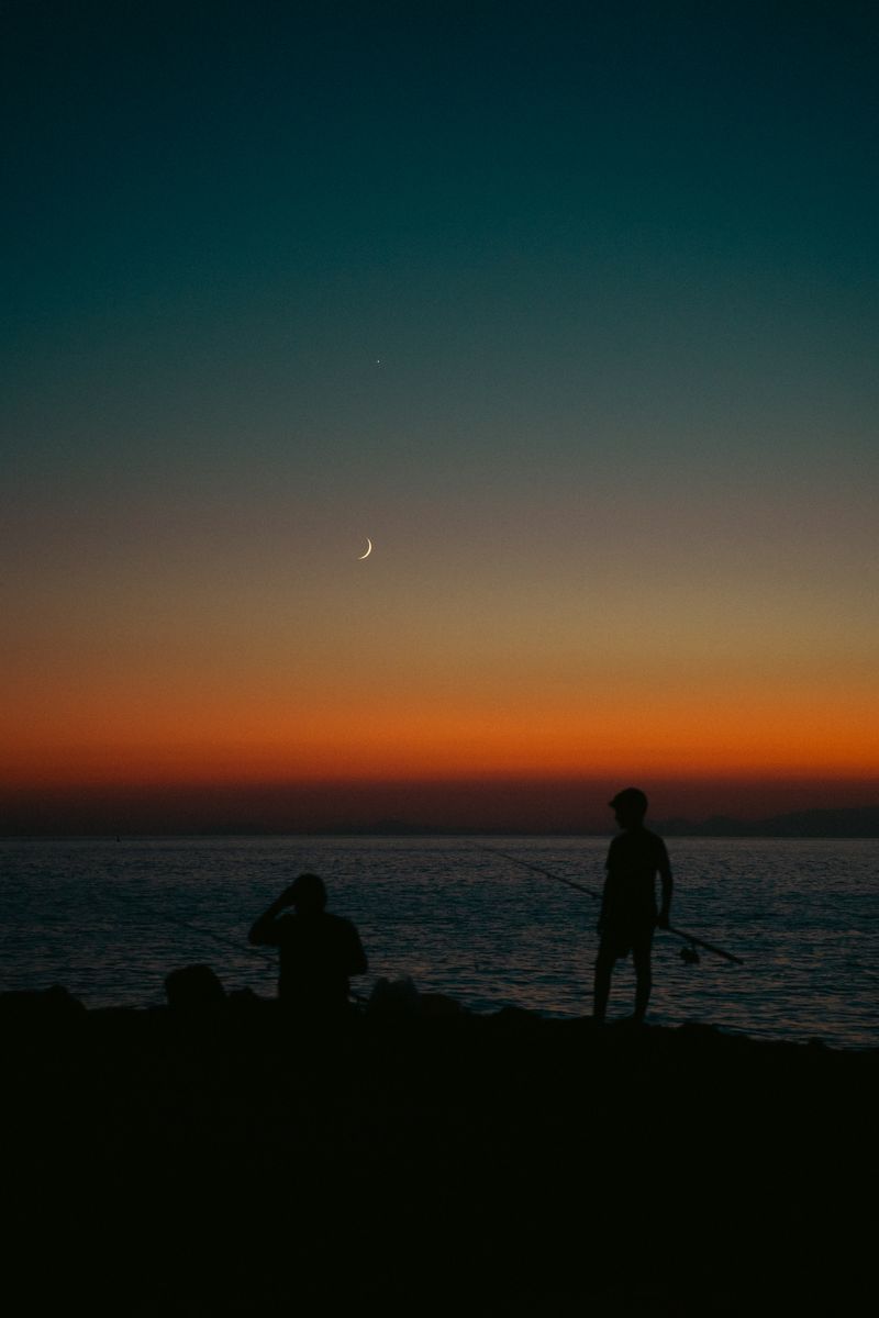 Night fishing at coastline under moonlight