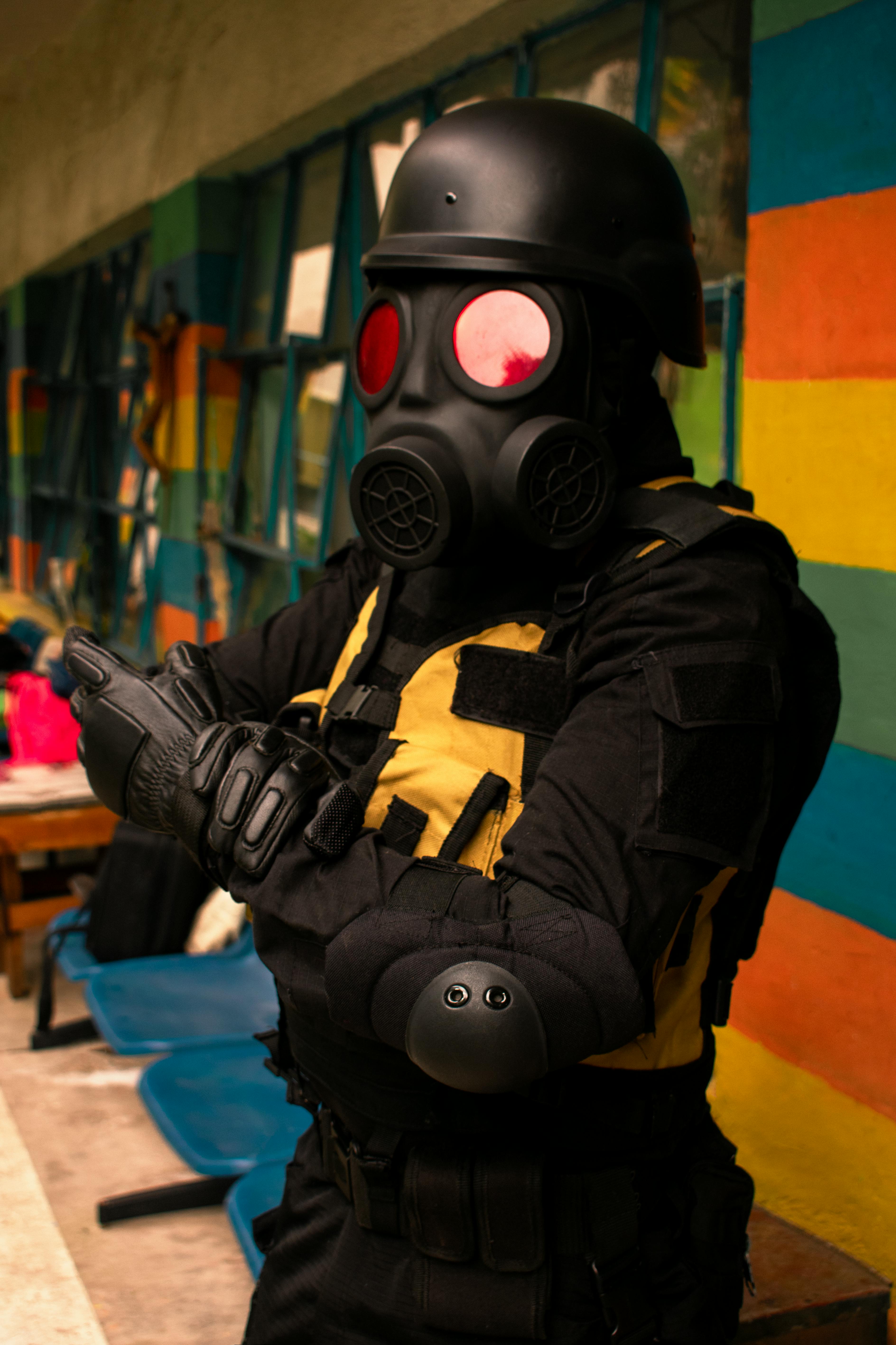 person in gas mask and tactical gear in urban setting