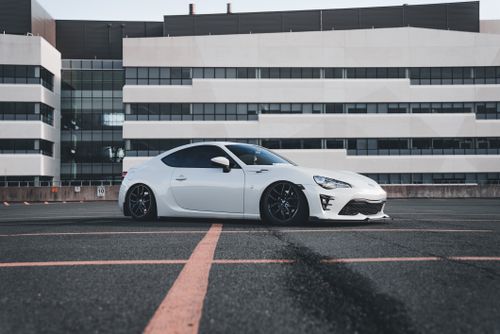 Free Modern white sports car parked in front of urban office building. Stock Photo