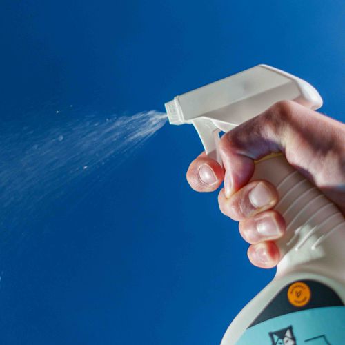 Free Close-up of a hand using pet-friendly cleaning spray, showcasing a high-quality product in action. Stock Photo