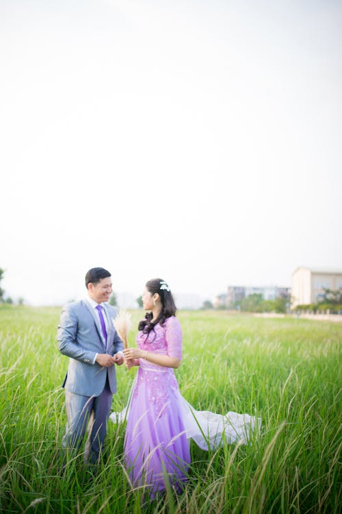 Photo of Couple Standing on Grass Field