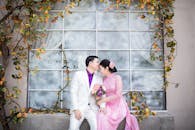 一对身着婚纱的浪漫情侣在秋叶装点的户外深情相拥