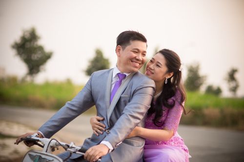 Free Bride and groom enjoying a romantic moment on a bicycle outdoors. Stock Photo