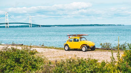 желтый Volkswagen Beetle на берегу моря