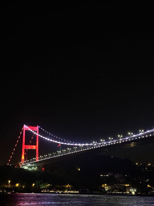 Free A striking night shot of the Bosphorus Bridge in Istanbul, lit with vibrant red lights. Stock Photo