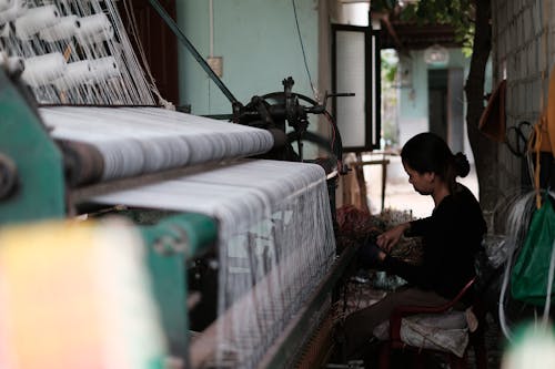 Женщина, работающая на текстильной машине