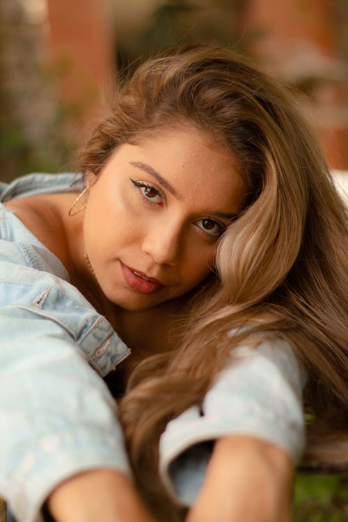 Free Close-up portrait of a young woman in a relaxed outdoor setting. Stock Photo