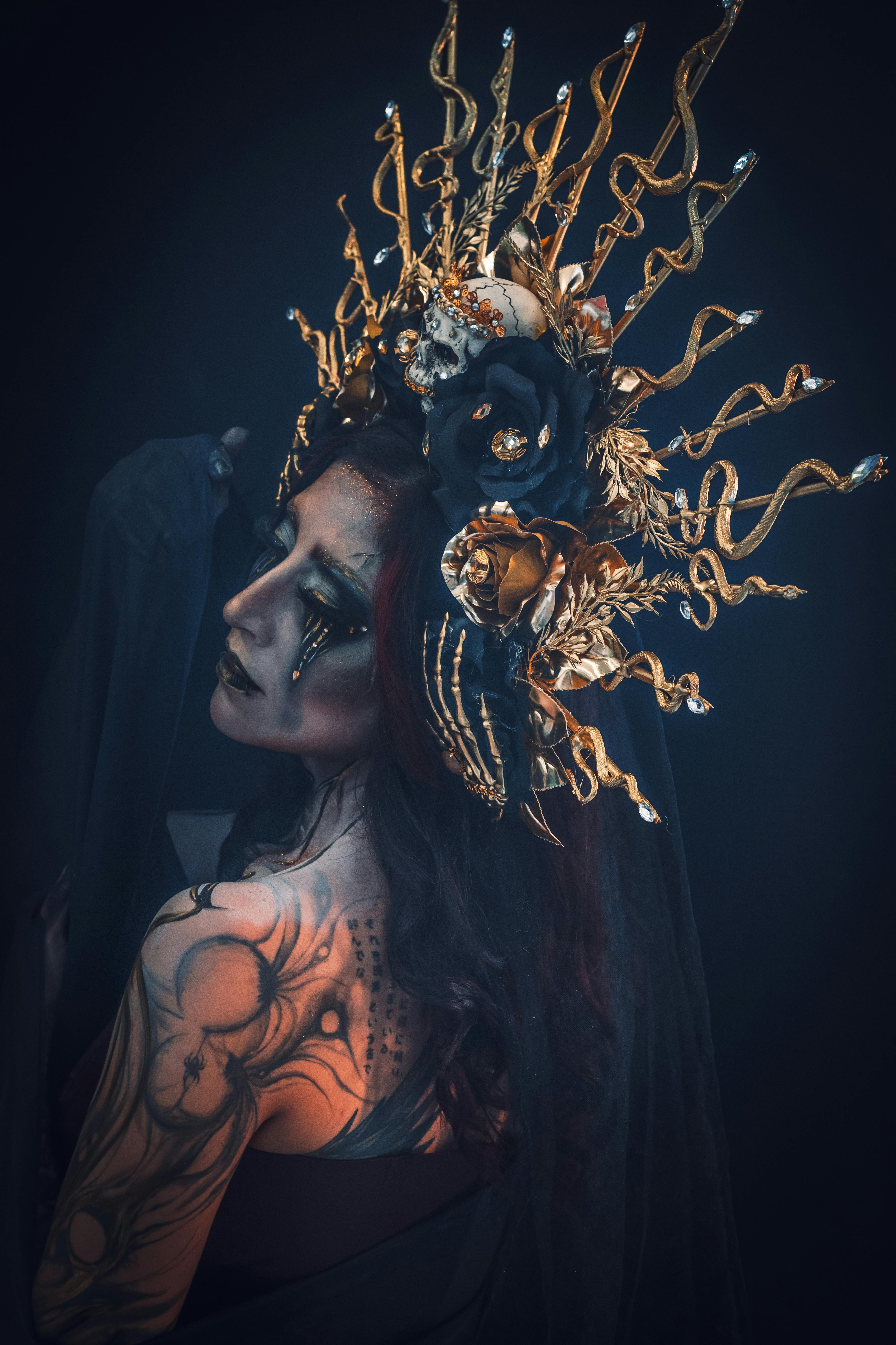 Eerie portrait of a woman with a gothic costume and intricate headpiece in dark tones.