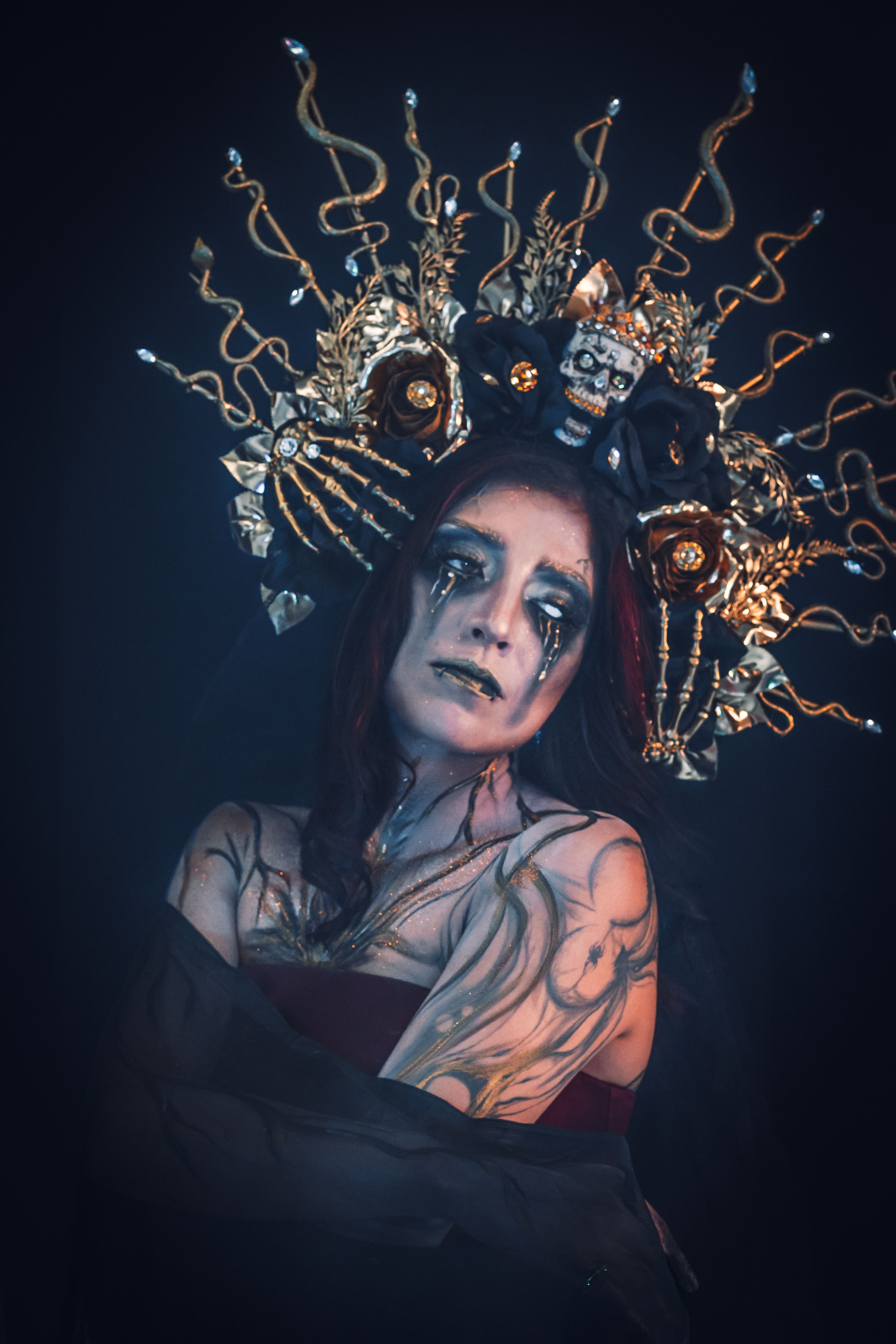 Portrait of a woman in intricate Halloween costume with dramatic makeup and headdress.