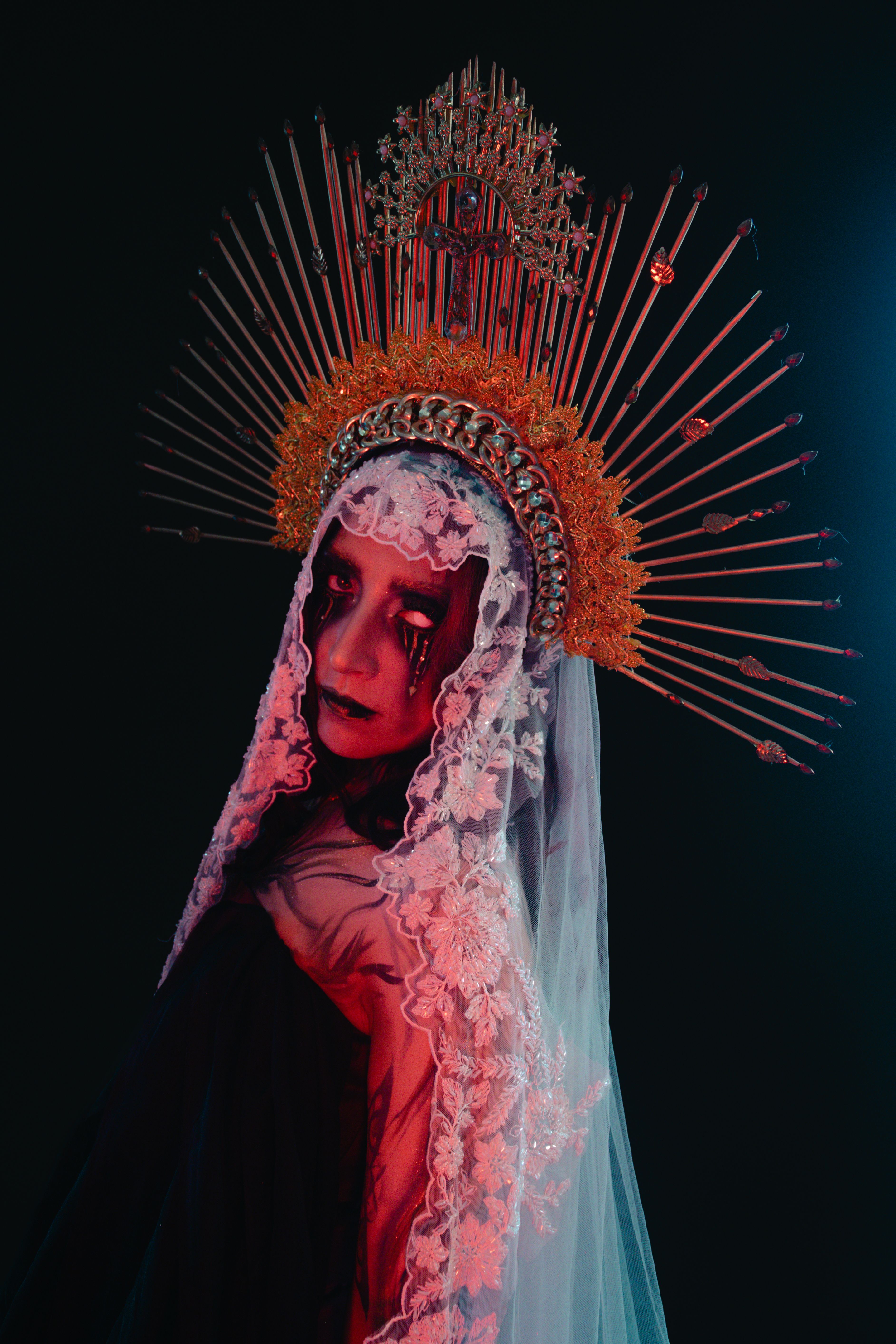 Dramatic portrait of a woman in elaborate Halloween costume with headdress.