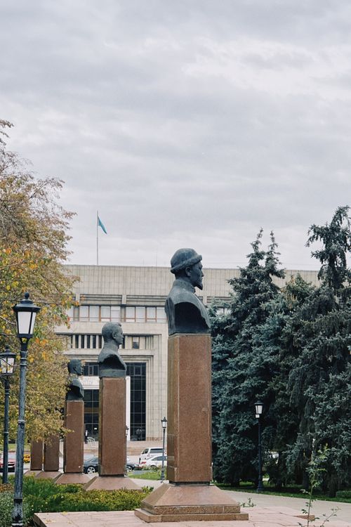 Free Bust statues stand prominently in front of a government building in Almaty, Kazakhstan. Stock Photo