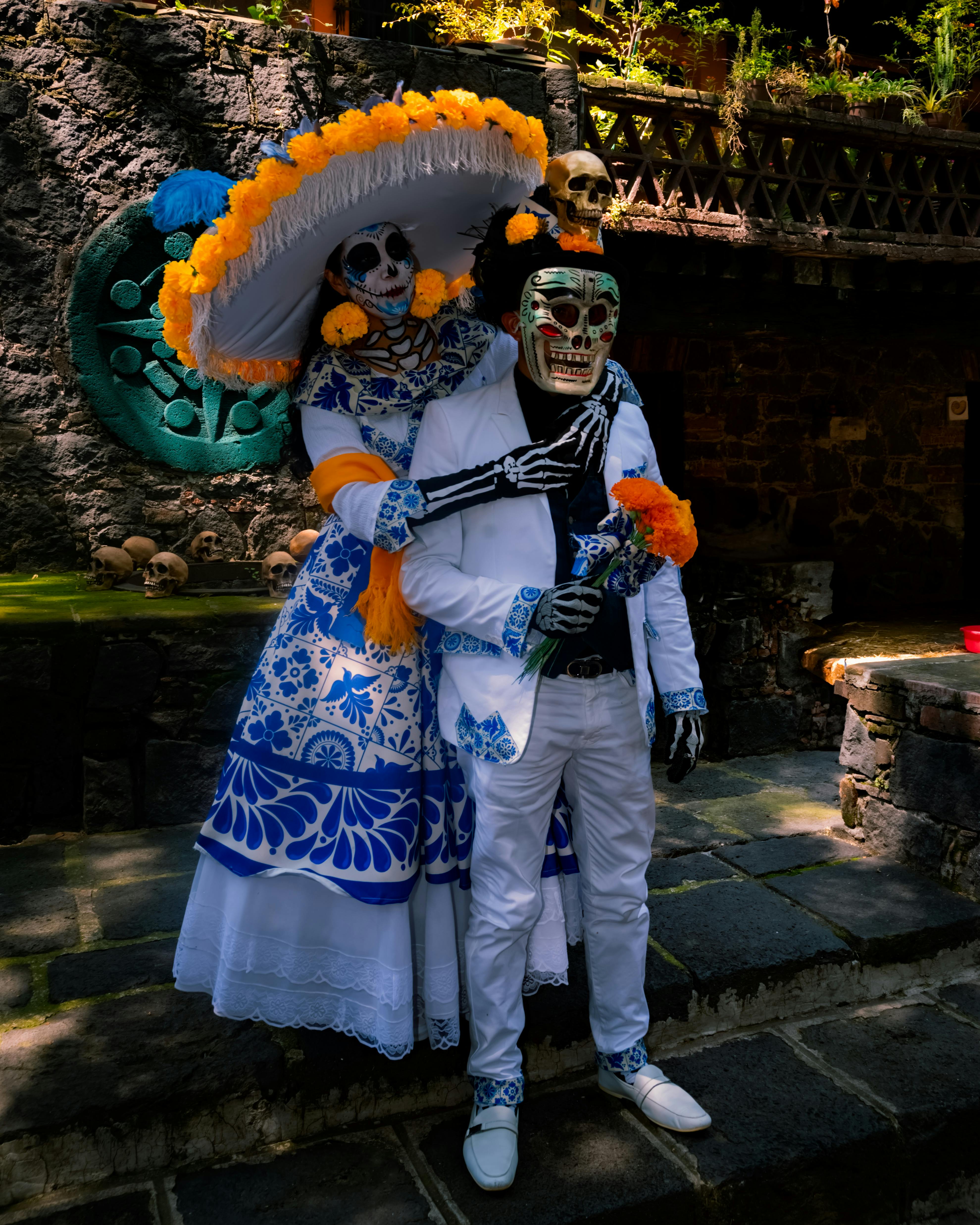 day of the dead themed couple in skeleton costumes