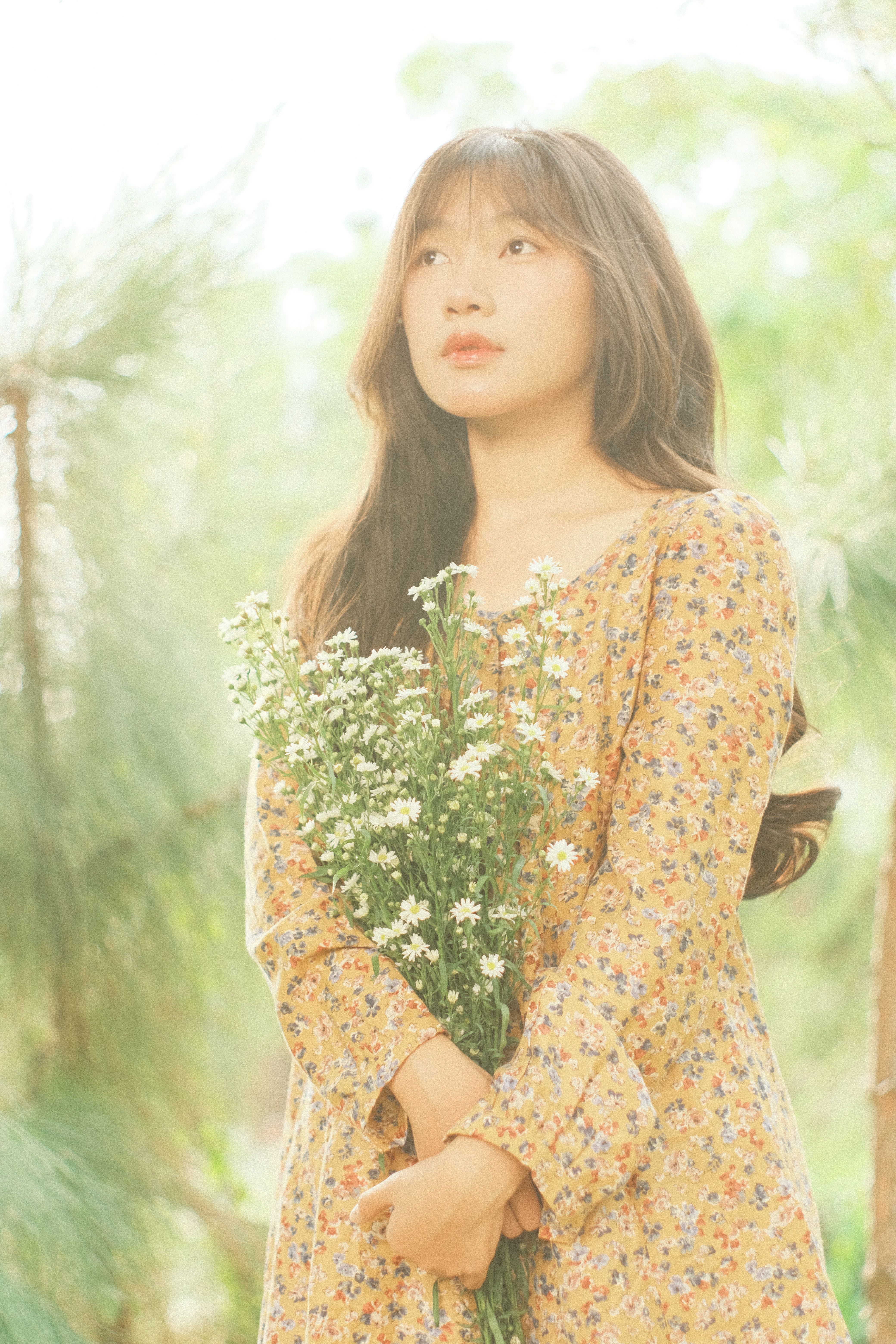 Young Woman in Floral Dress Holding Wildflowers · Free Stock Photo