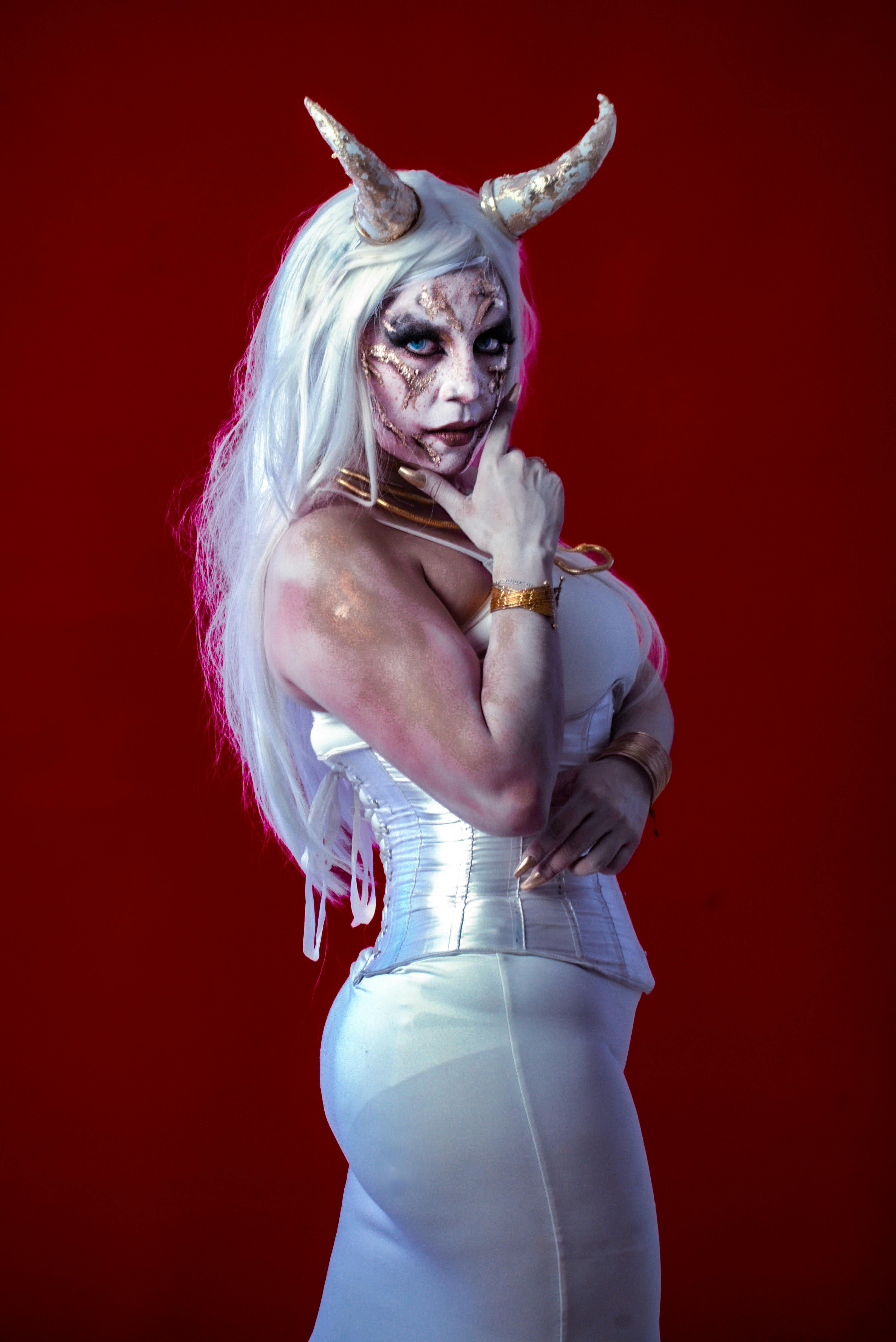 grátis Retrato De Traje Enigmático Com Chifres Contra Vermelho Foto profissional