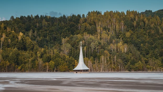 这座风景如画的教堂，四周环绕着郁郁葱葱的森林和宁静的湖泊，照片拍摄于一个阳光明媚的夏日