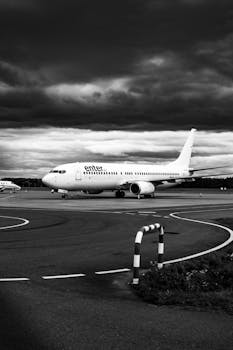 Black and white photo of an airplane on the runway at Wrocław Airport, Poland.