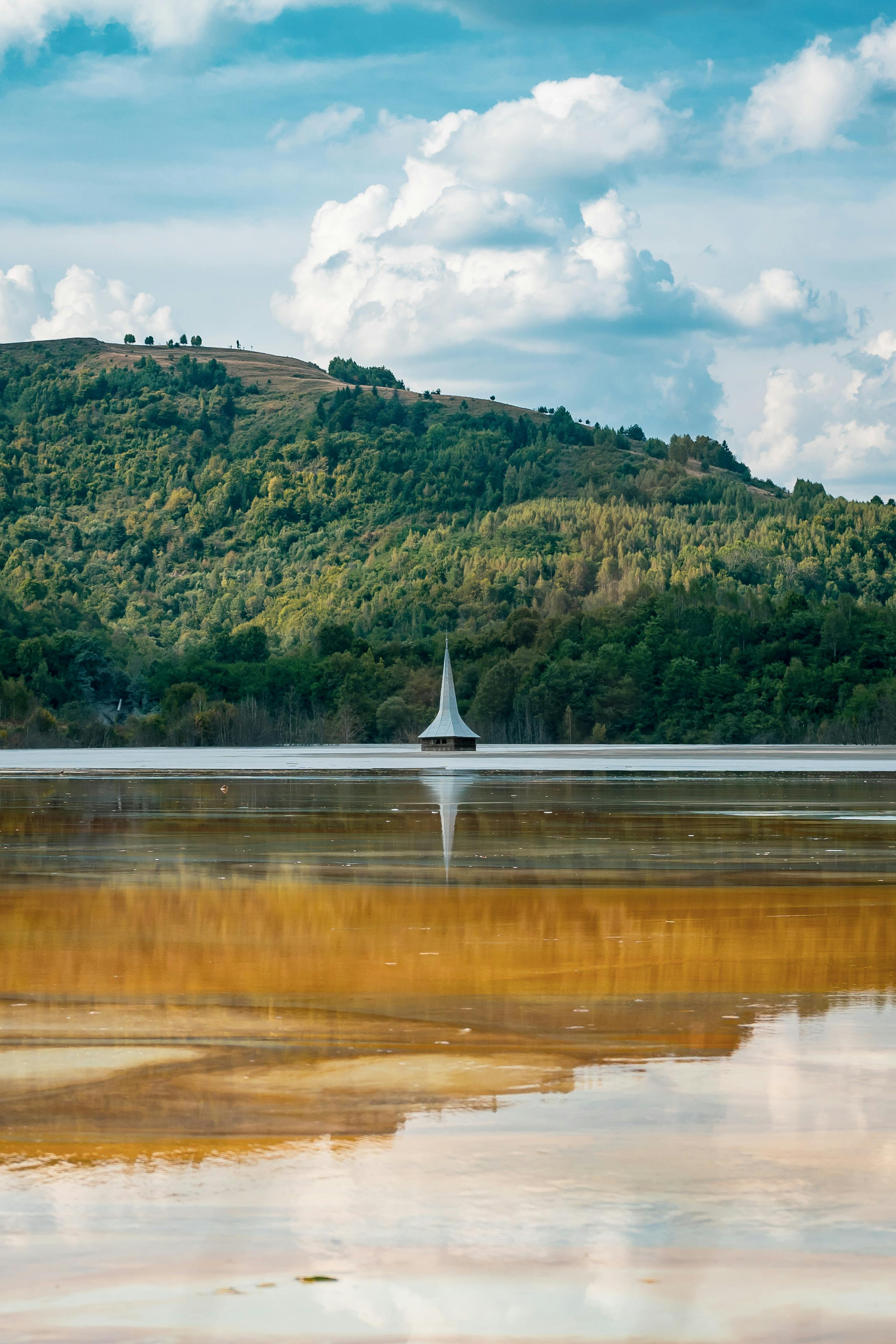 宁静的湖水中倒映着教堂的尖顶，映衬在郁郁葱葱的绿色山坡上