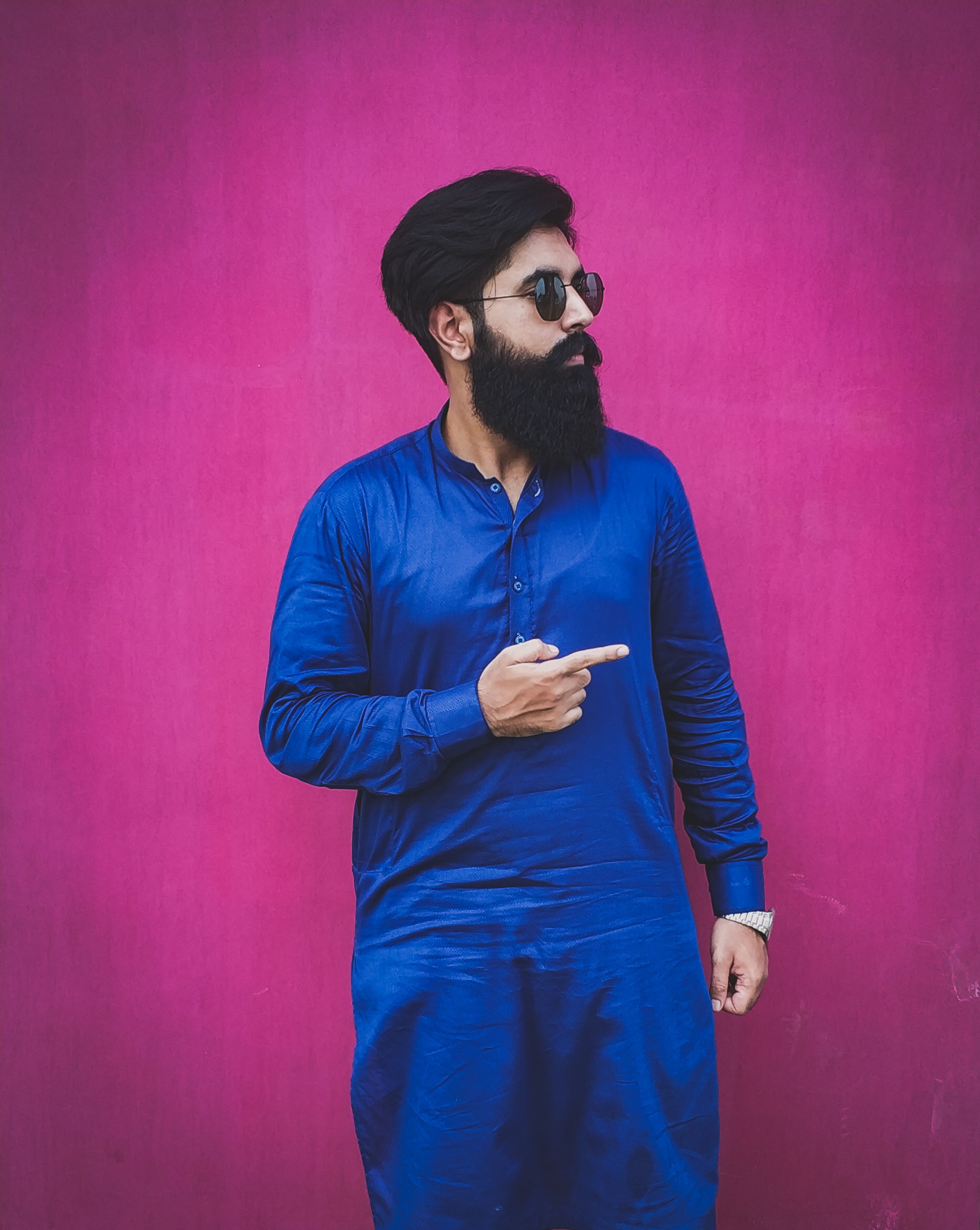 Man with beard and sunglasses in blue kurta pointing, stylish look. - Tips for Mixing and Matching Outfits