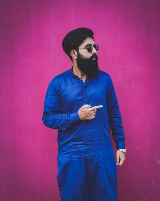 Man with beard and sunglasses in blue kurta pointing, stylish look. - Tips for Mixing and Matching Outfits