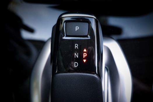 Detailed view of a modern automatic car gear shifter displaying P, R, N, D settings.