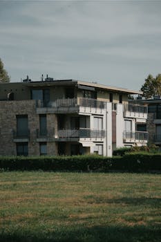 A contemporary apartment building set amidst greenery in Hungary, showcasing modern architecture.