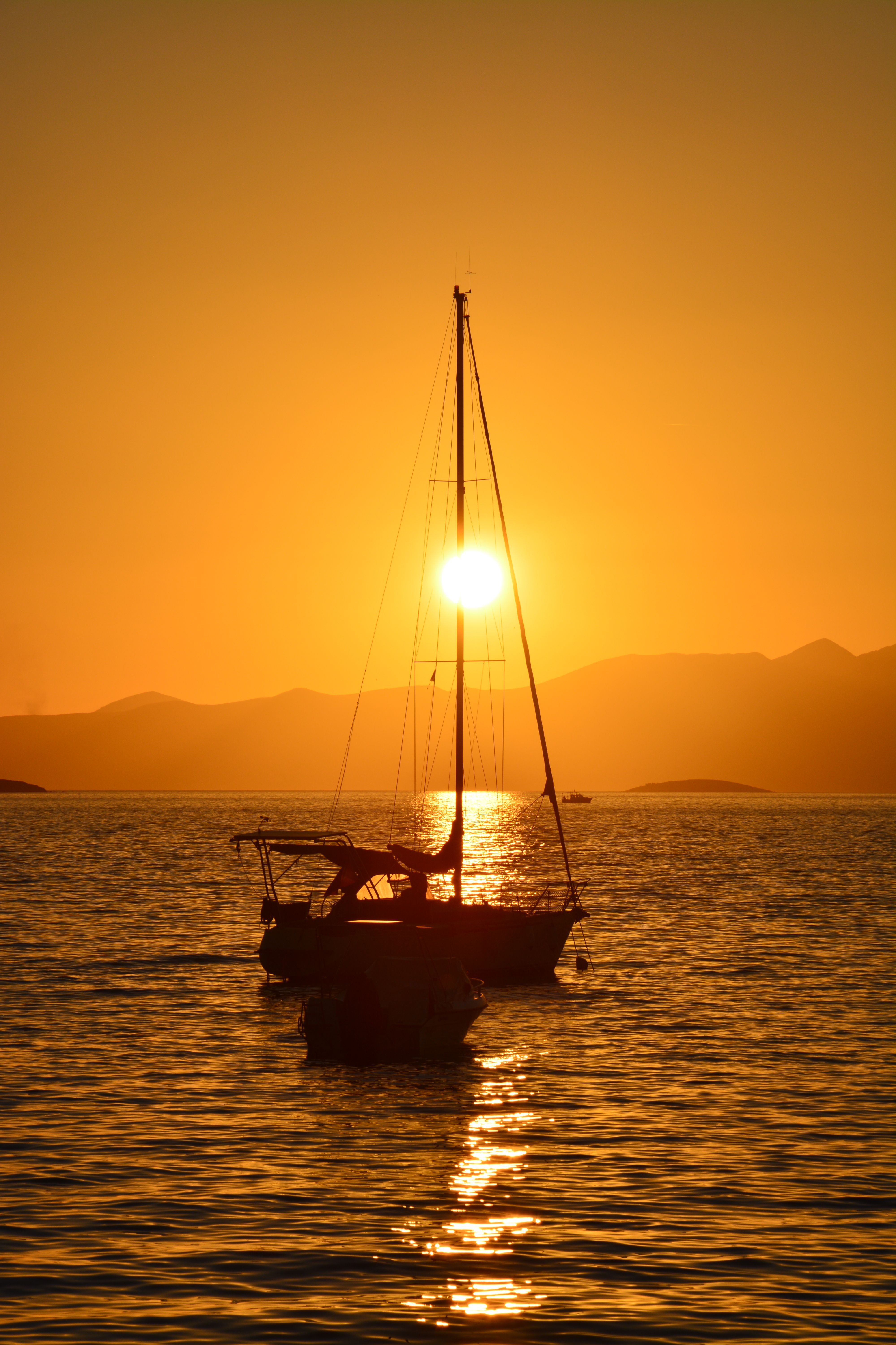 Serene Sailboat at Golden Sunset on Calm Sea · Free Stock Photo